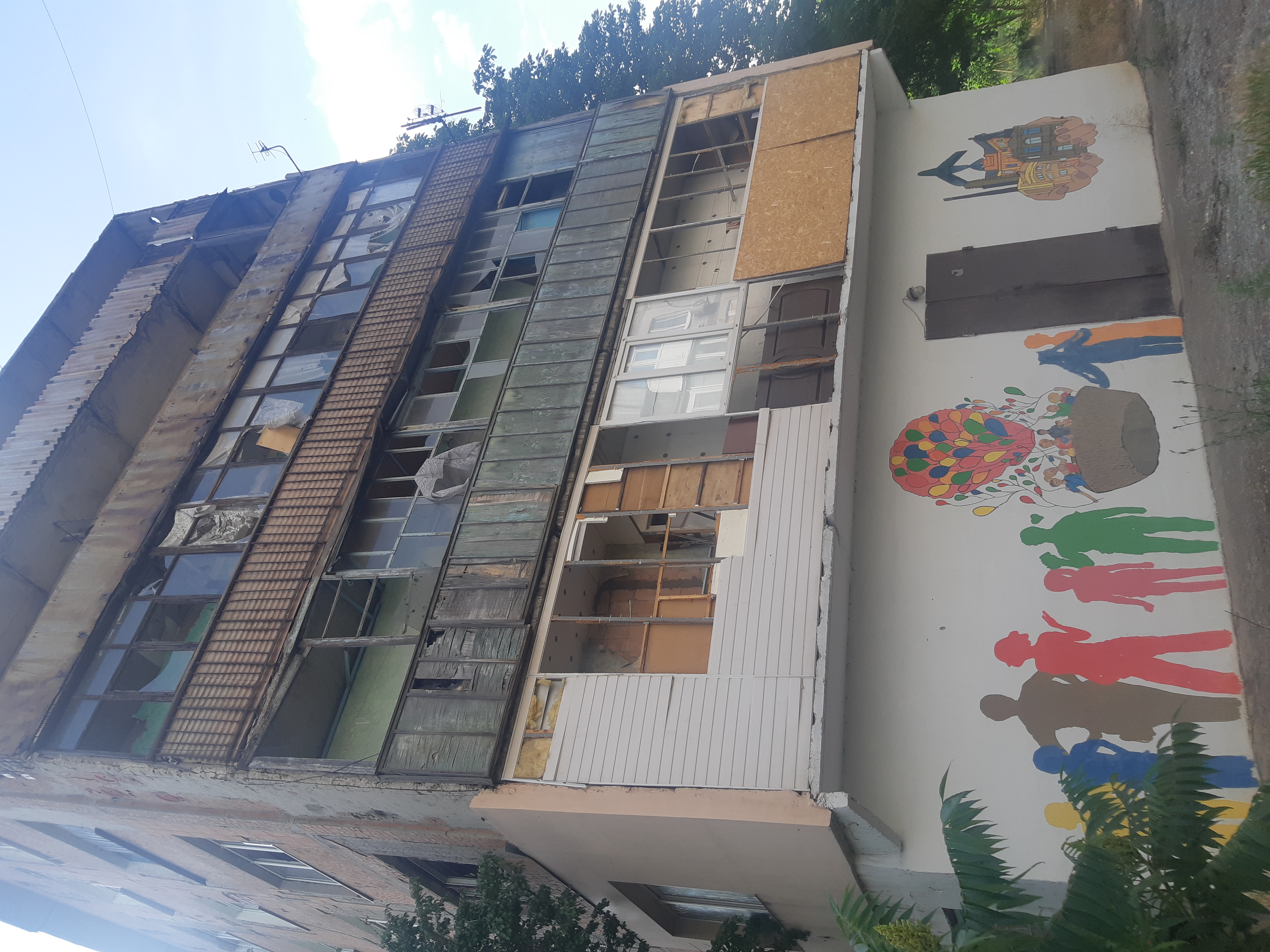War-damaged apartment block with children mural